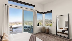 A hotel room with a large bed, a seating area with a view, and a balcony with a pool. - The Mandarin - Pool, Spa, Sauna, Sunken Fire Pit, Amazing Views (Yucca Valley)