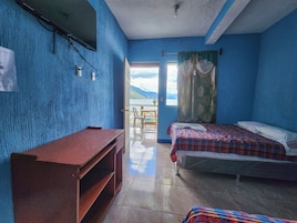 Una habitación con cama, escritorio y vista al exterior.