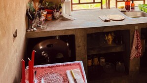 Uma cozinha com janela, pia e diversos utensílios.