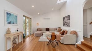 Ein geräumiges Wohnzimmer mit einer Sofagarnitur, einem Couchtisch und einem Kamin.