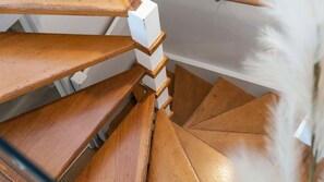 Een houten wenteltrap met witte leuningen.