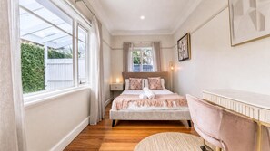 A bedroom with a bed, bedside table, lamp, and a view of the outside. - The Ringwood Rambler Yard  Family Retreat (Ringwood)