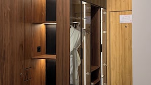 Un vestidor con estantes de madera, un espejo y un perchero.