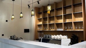Una cocina moderna con iluminación colgante, estanterías de madera y encimera blanca.