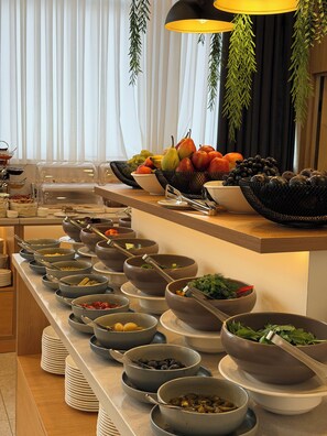 Un buffet proposant une variété de plats et d’ustensiles de service.