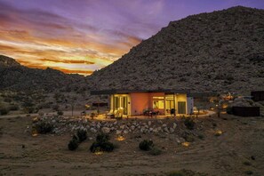 A modern building with a patio area, surrounded by a rocky landscape. - Desert Contemporaine - Stargazer's Oasis - Hot Tub - Desert Views (Joshua Tree)