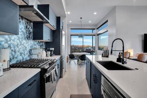 A modern kitchen with a large island, built-in appliances, and a view to the outside. - Desert Contemporaine - Stargazer's Oasis - Hot Tub - Desert Views (Joshua Tree)