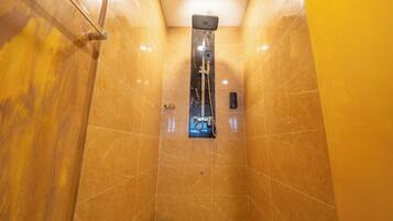Baño con ducha, espejo y lavamanos.