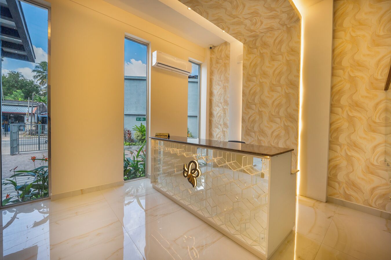 A reception area with a glass counter, a reception desk, and a patterned wall.