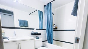 Een badkamer met toilet, wastafel en bad.