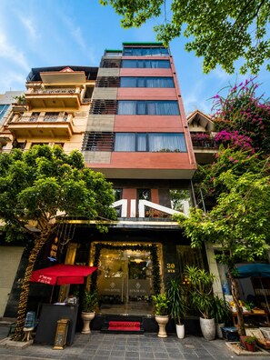 Ein Hotel mit moderner Fassade, einer roten Markise und einem einladenden Eingang.