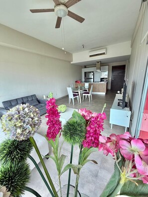 A modern living space with a dining area, kitchen, and a ceiling fan. - Beautiful, relaxing and convenient in Nuevo Vallarta! (Nuevo Nayarit)