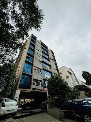 Um edifício de vários andares com um andar comercial na parte inferior, incluindo um hotel e um banco.
