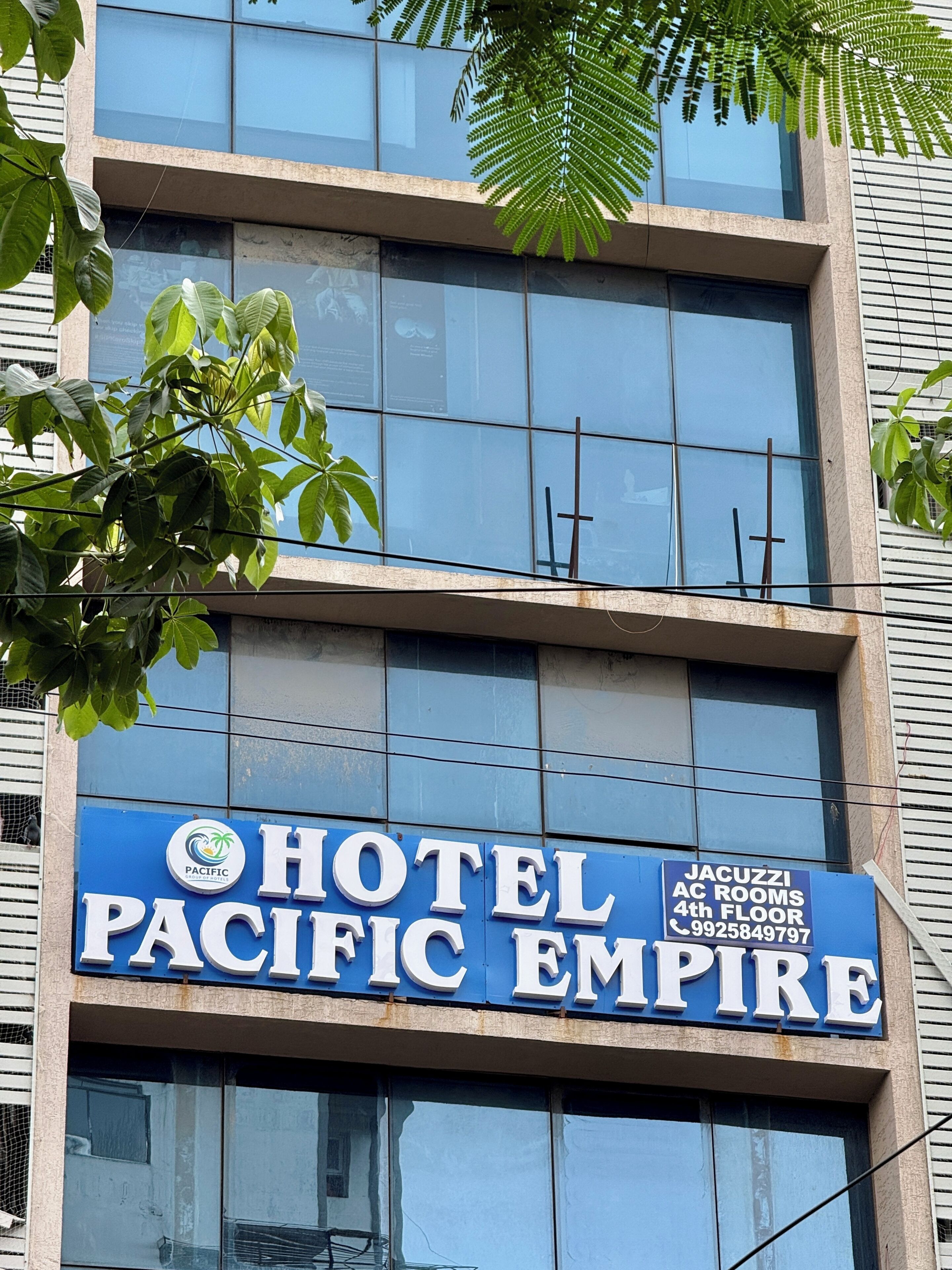 Letrero de hotel con la leyenda 'PACIFIC EMPIRE' y 'HABITACIONES CON JACUZZI, 4TO PISO', junto con un número de teléfono.