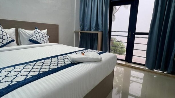 Una habitación de hotel con una cama grande, una ventana con cortinas y vistas al exterior.