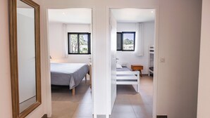 Ein Hotelzimmer mit Bett, Schreibtisch und Blick ins Freie durch die Fenster.