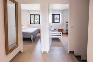A hotel room with a bed, a desk, and a view of the outdoors through the windows. - Villa - 3 bedrooms - 800 meters from Cala Rossa Beach (Lecci)