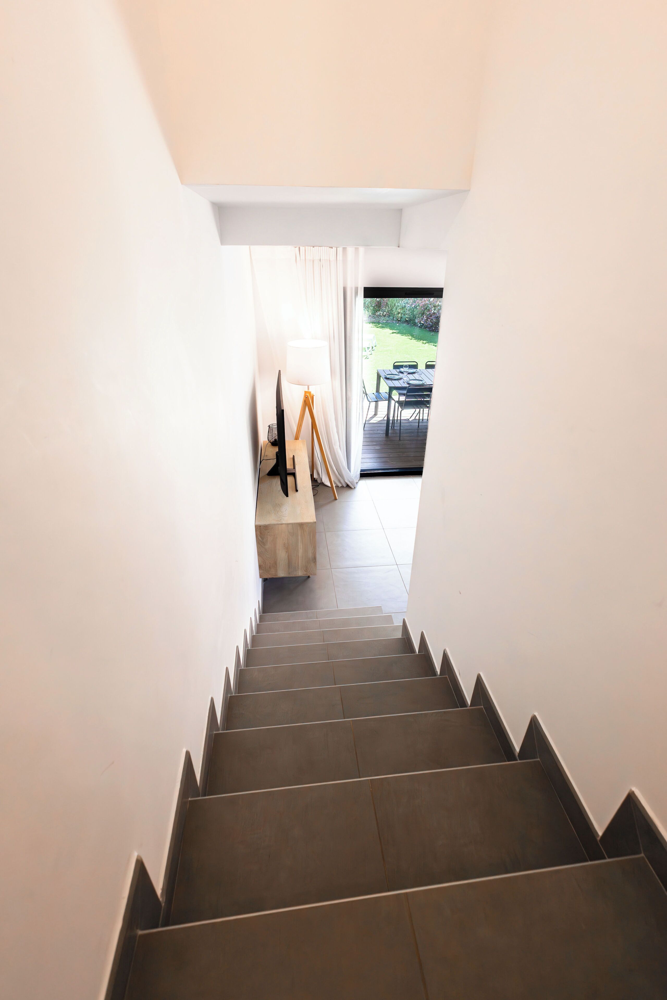 A staircase leading to a dining area with a table set for two.