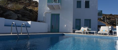 Ein modernes Gebäude mit Pool, weißen Wänden und blauen Akzenten.