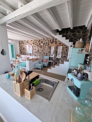 A modern kitchen with a stone wall, a sink, and a vintage toaster. - 65 Stairs To Heaven Private Villa (Folegandros)