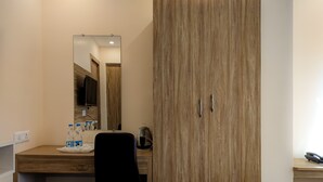 A hotel room with a wooden wardrobe, a desk with a mirror, and a chair. - Hotel Vaikunth (Sahibganj)