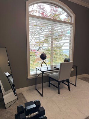 A room with a desk, chair, and a large window with blinds. - Spacious 7-bedroom house in beautiful North Salt Lake (North Salt Lake)