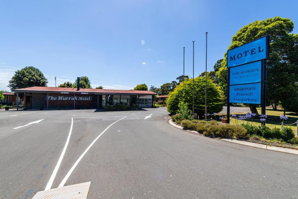 A motel with a signboard indicating amenities like BBQ, pool, free wifi, and free parking.