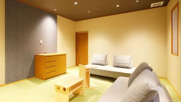 A room with a sofa, a wooden cabinet, and a small table.