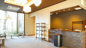 A reception area with a reception desk, seating area, and a shelving unit. - Gourmet Ryokan Mikawaya (Okawa)