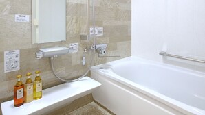 A modern bathroom with a bathtub, a shower, a sink, and a mirror. There are toiletries on the sink counter. - Gourmet Ryokan Mikawaya (Okawa)