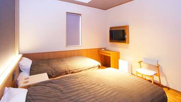 A hotel room with two beds, a television, a desk, and a chair.