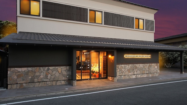 A modern two-story building with a stone facade and a flat roof. - Gourmet Ryokan Mikawaya (Okawa)