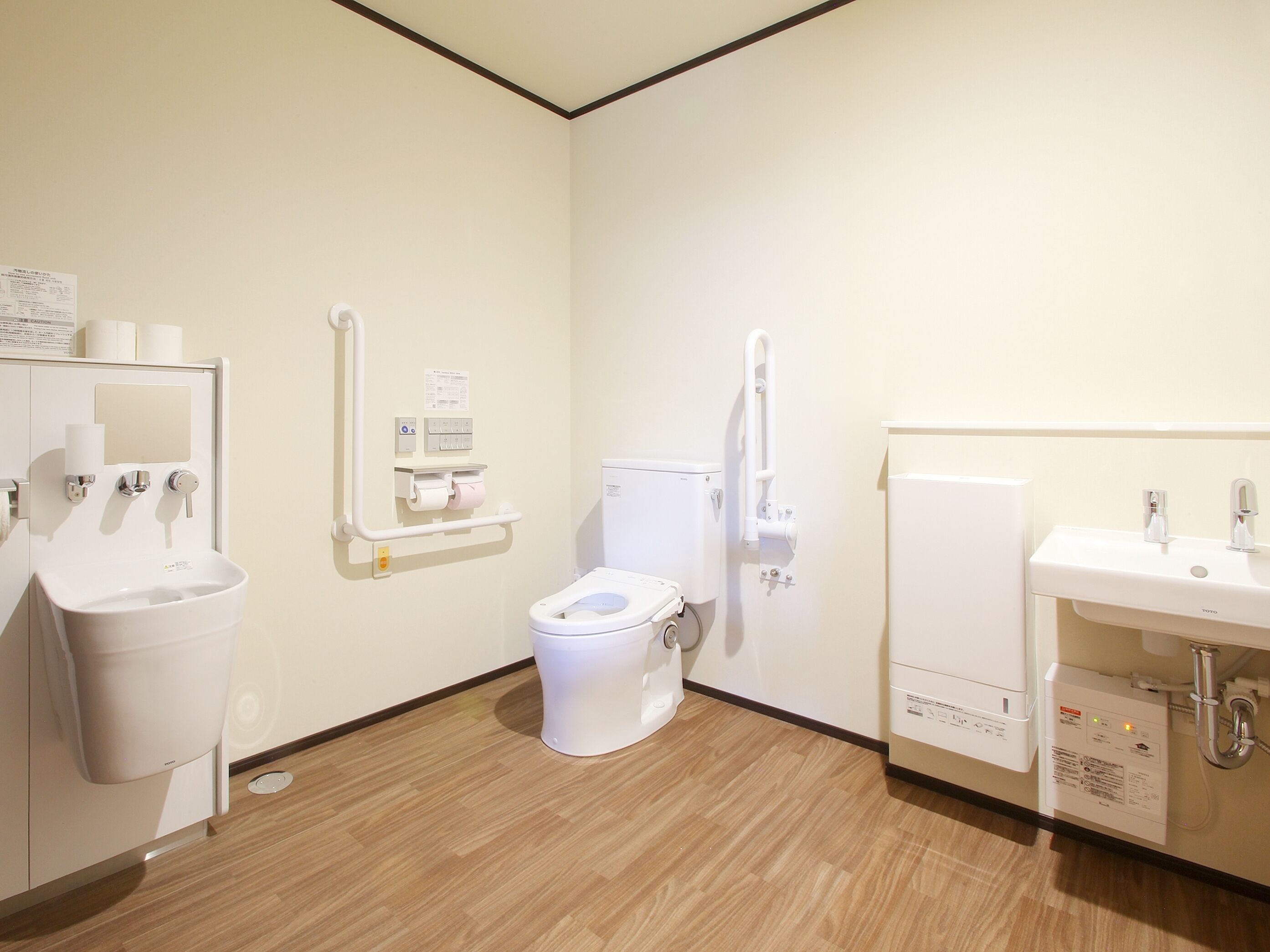 A modern bathroom with a toilet, sink, and hand dryer.
