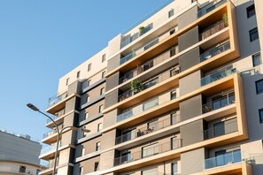 Ein mehrstöckiges Wohngebäude mit Balkonen, großen Fenstern und einem modernen architektonischen Design.