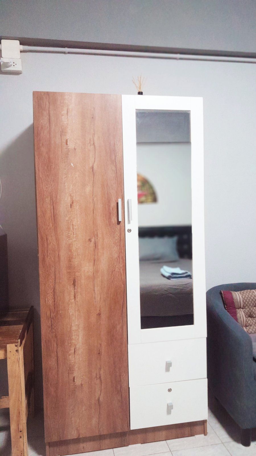 Une armoire avec une porte en bois et une partie avec un miroir.