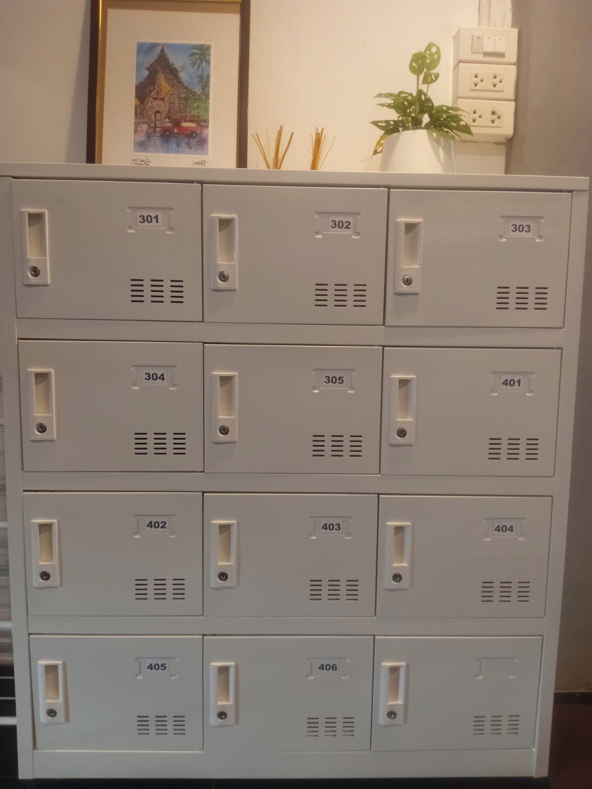 A set of grey metal storage units with numbered compartments, likely used for storing guest belongings.