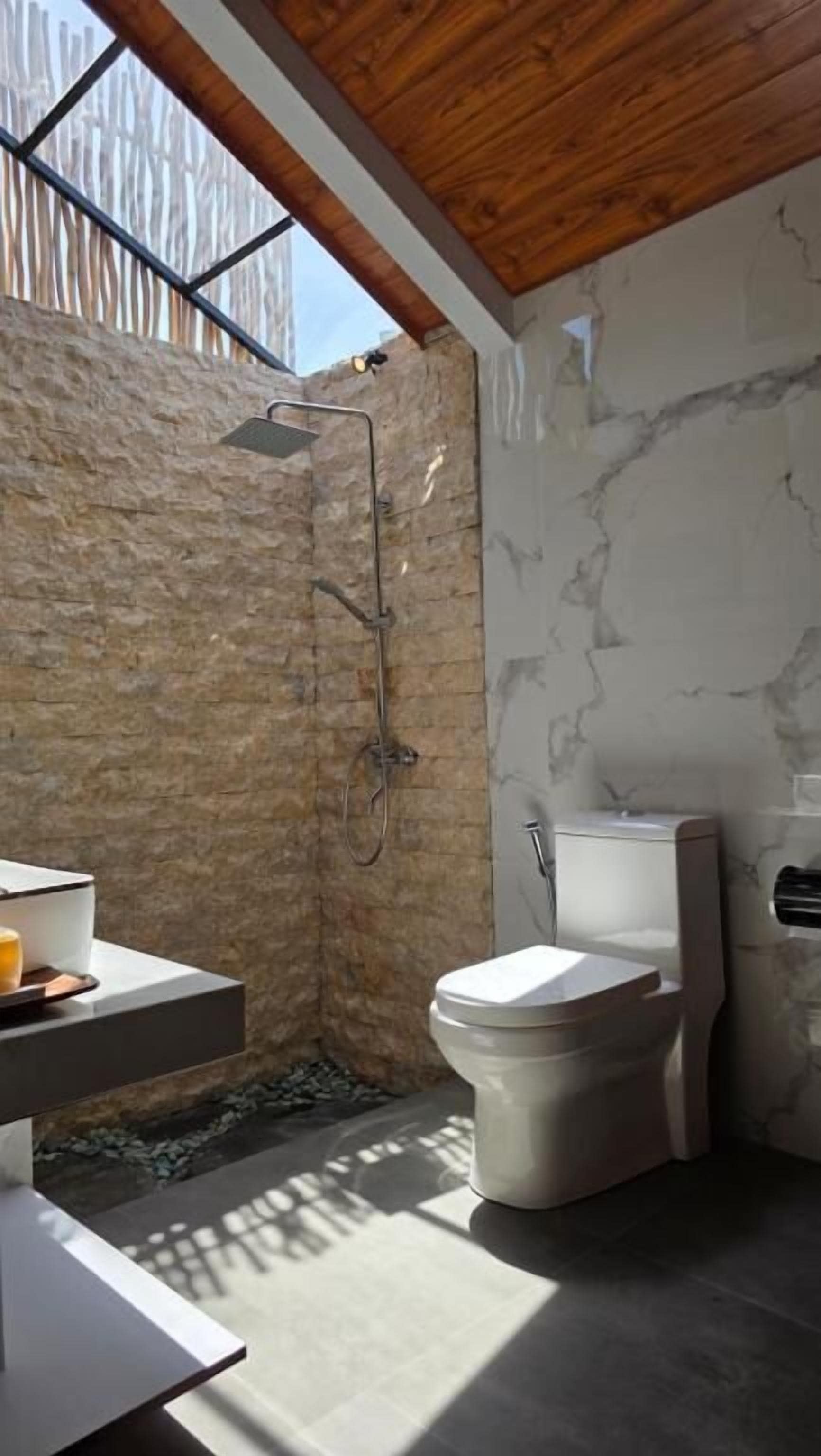 Une salle de bain avec une douche, des toilettes et un lavabo.