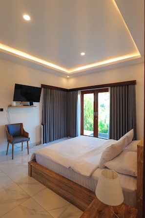 A modern bedroom with a large bed, a TV mounted on the wall, and a window with curtains.