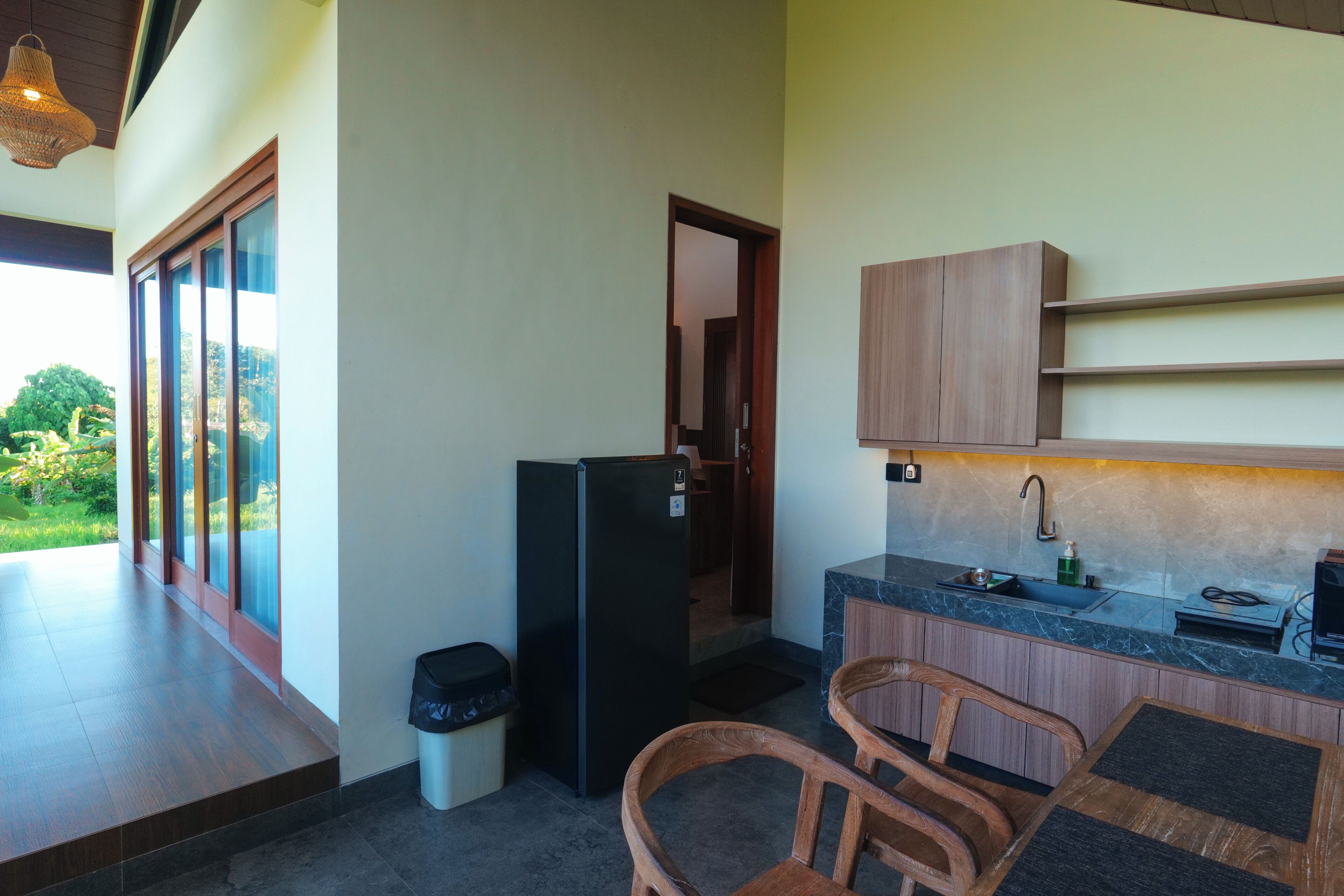 Una cocina compacta con refrigerador, pileta y alacenas de madera.