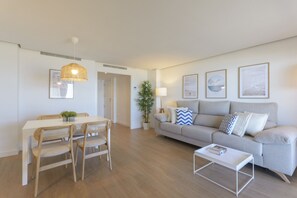 Un salon moderne comprenant un coin repas, un ensemble de canapés et une table basse.