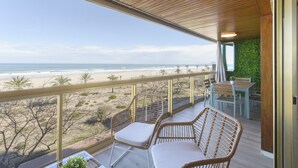 A balcony with wicker chairs, a table, and a view of the beach and ocean. - VACACIONES FRENTE AL MAR - Only families (Playa de Gandía)