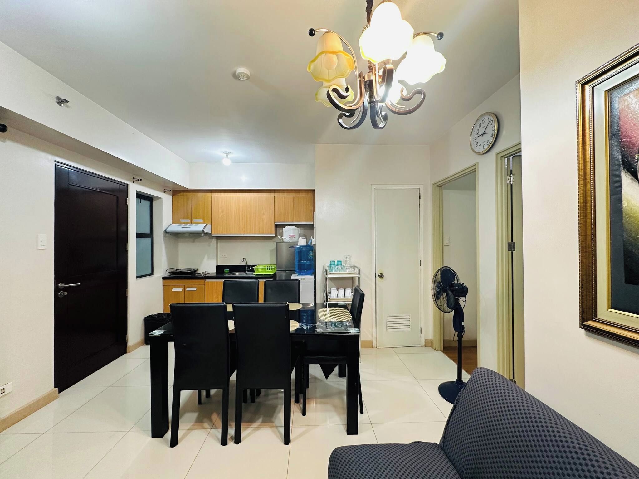 A compact living space with a dining area, kitchenette, and a sofa.