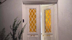 A white door with a decorative glass panel and a potted plant beside it. - The House of Olive Trees (La Marsa)