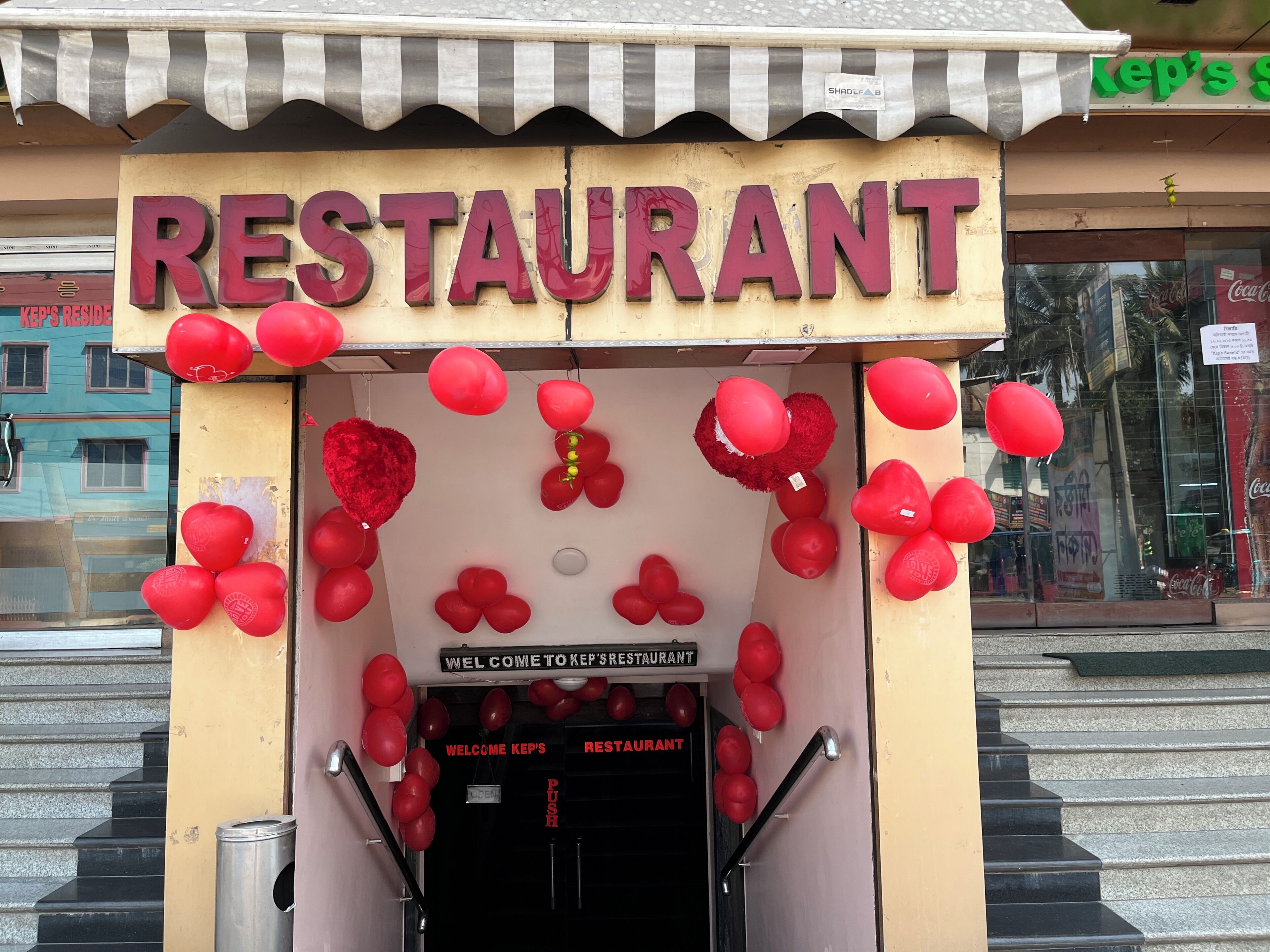 A restaurant entrance with a sign reading 'RESTAURANT' and balloons.