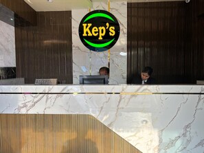 Un mostrador de recepción con encimera de mármol y un cartel que dice 'KeP's'.