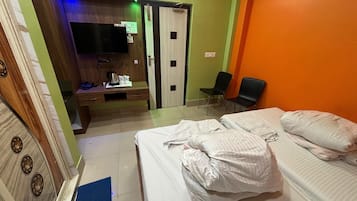 Een hotelkamer met een bed, een bureau met een flatscreen televisie, een stoel en een kledingkast.