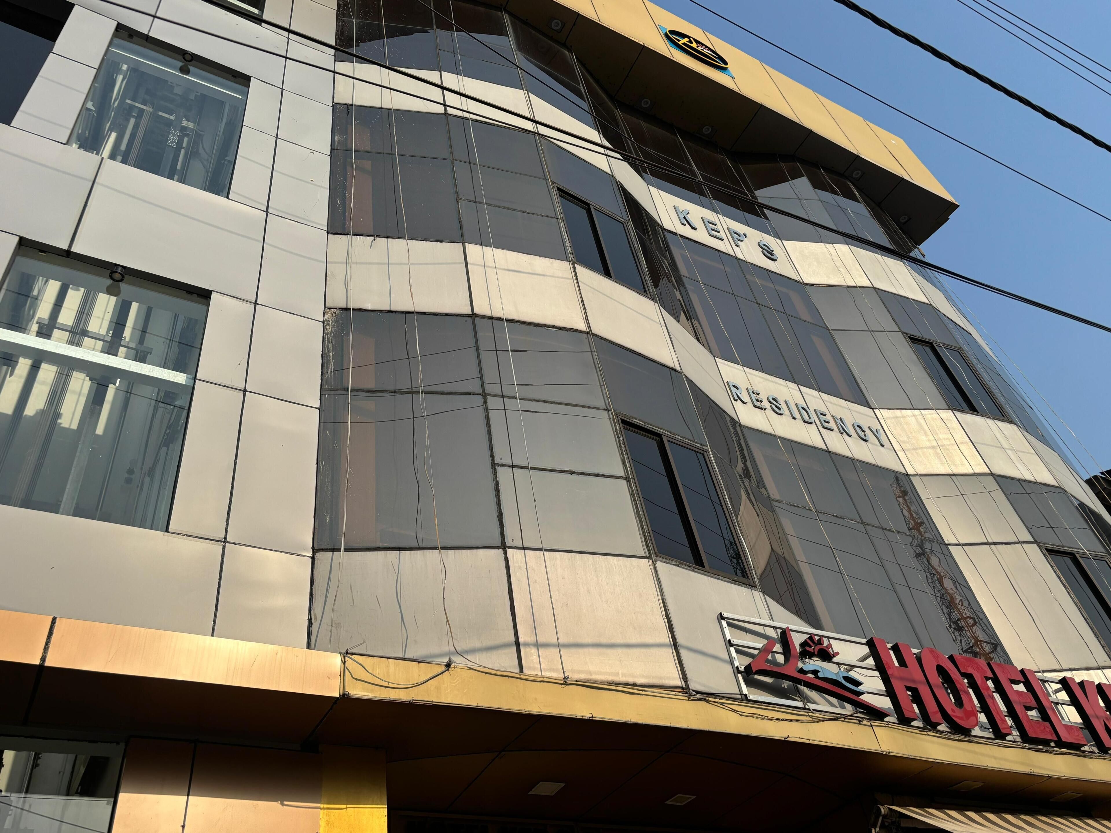 A hotel building with a modern facade, large windows, and a prominent 'HOTEL' sign.