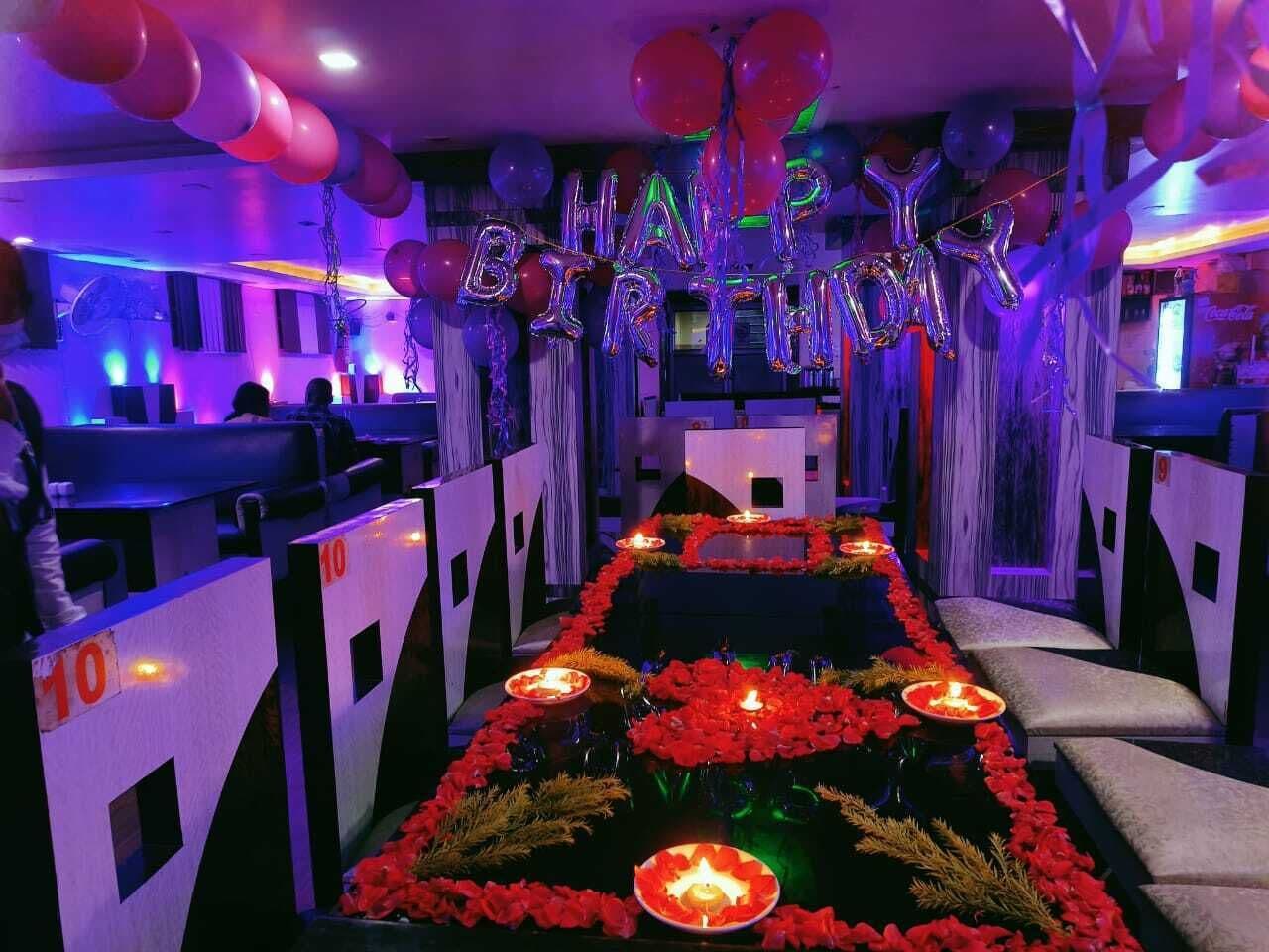A venue with a central aisle decorated with flowers and candles, flanked by seating areas.