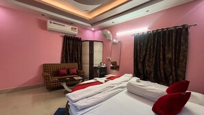 Une chambre d’hôtel équipée d’un lit, d’un canapé, d’un miroir et d’un appareil de climatisation.