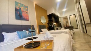 Ett hotellrum med två sängar, en matplats och ett kök.